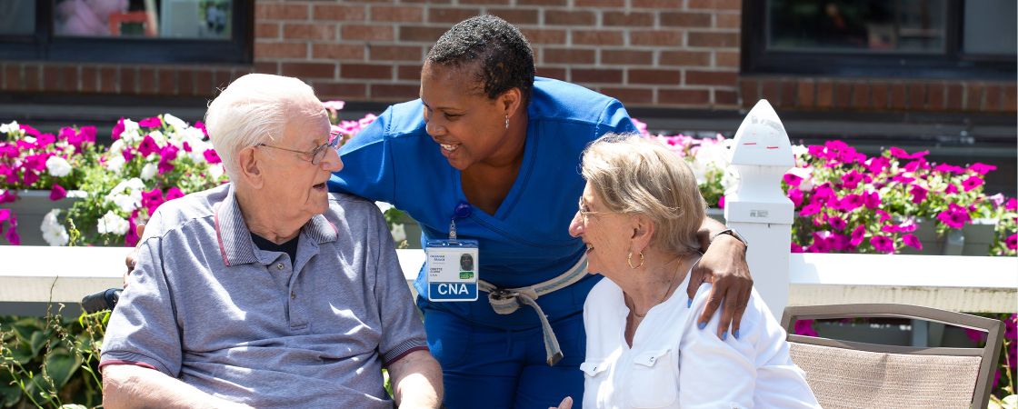 Nurse with arms around two patients