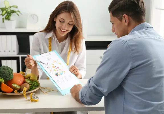Dietitian advising client with chart of healthy food options.