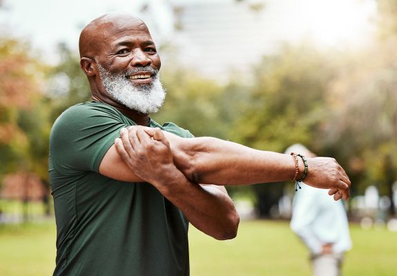 Elderly man stretching arm