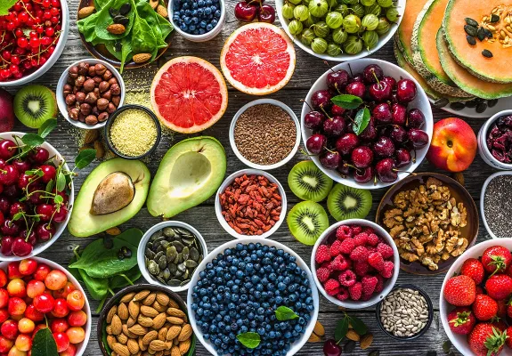 Top-down view of a healthy spread of fruits and nuts on a table.