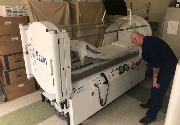 Nurse pushing buttons on hospital machine equipment
